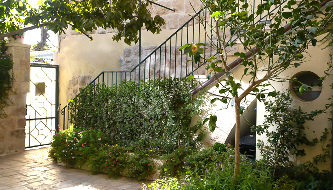 Planting in garden boxes and pots at patio borders to create green, blooming envelope, leaving a clear paved area